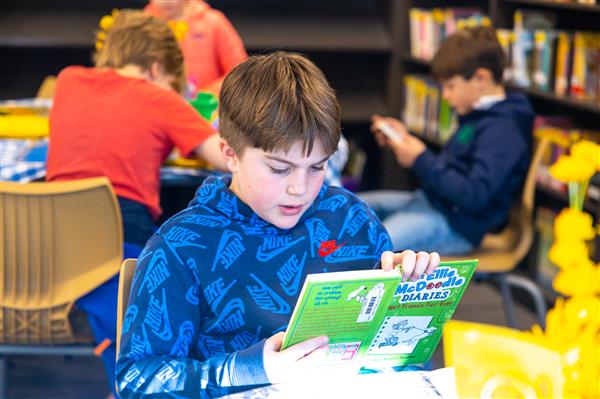 Students browsing new books that have been added to the Scales Library.